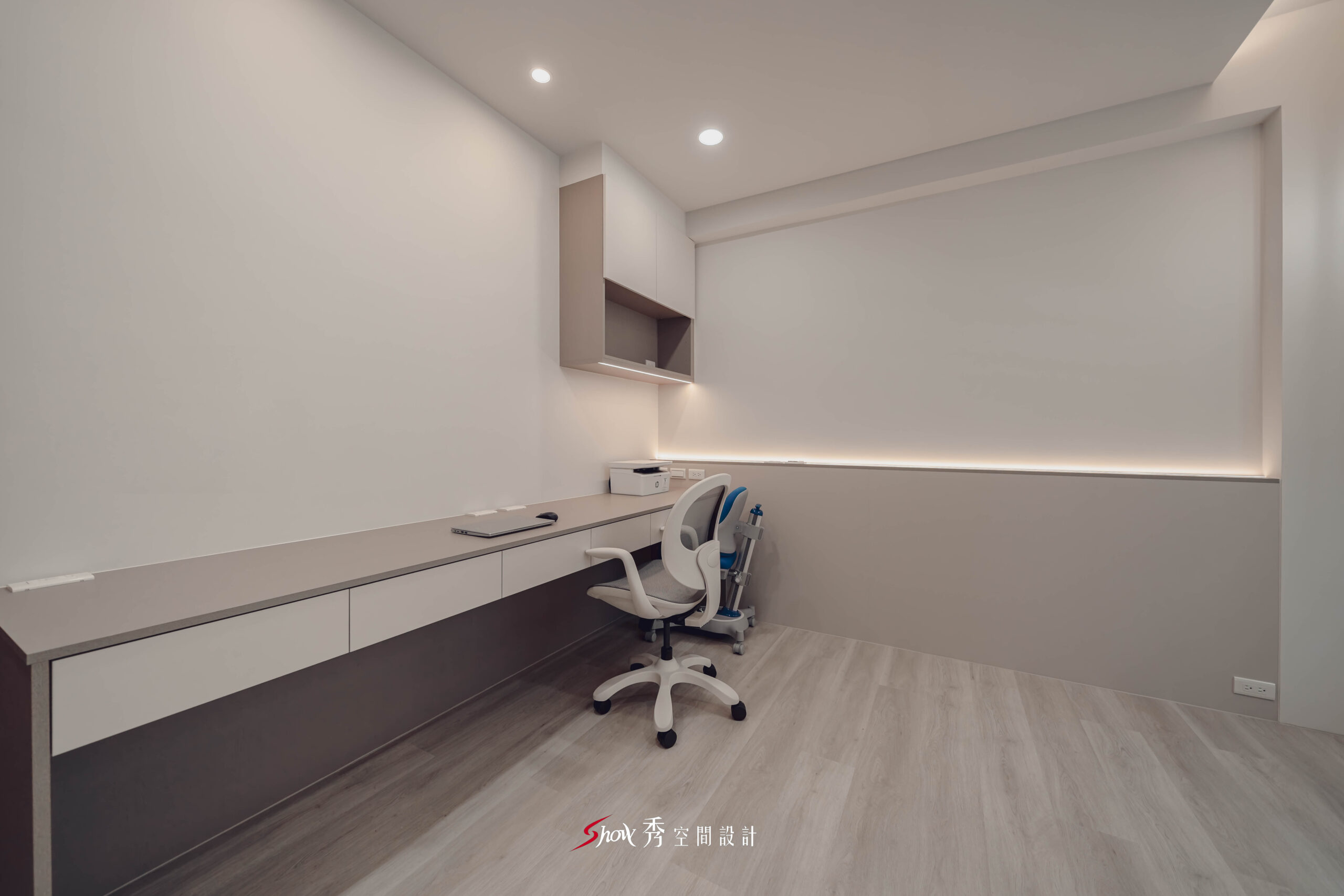 台南善化透天老屋翻新書房，以大面留白牆面、長型書桌與收納上櫃構成簡潔俐落的多功能空間。