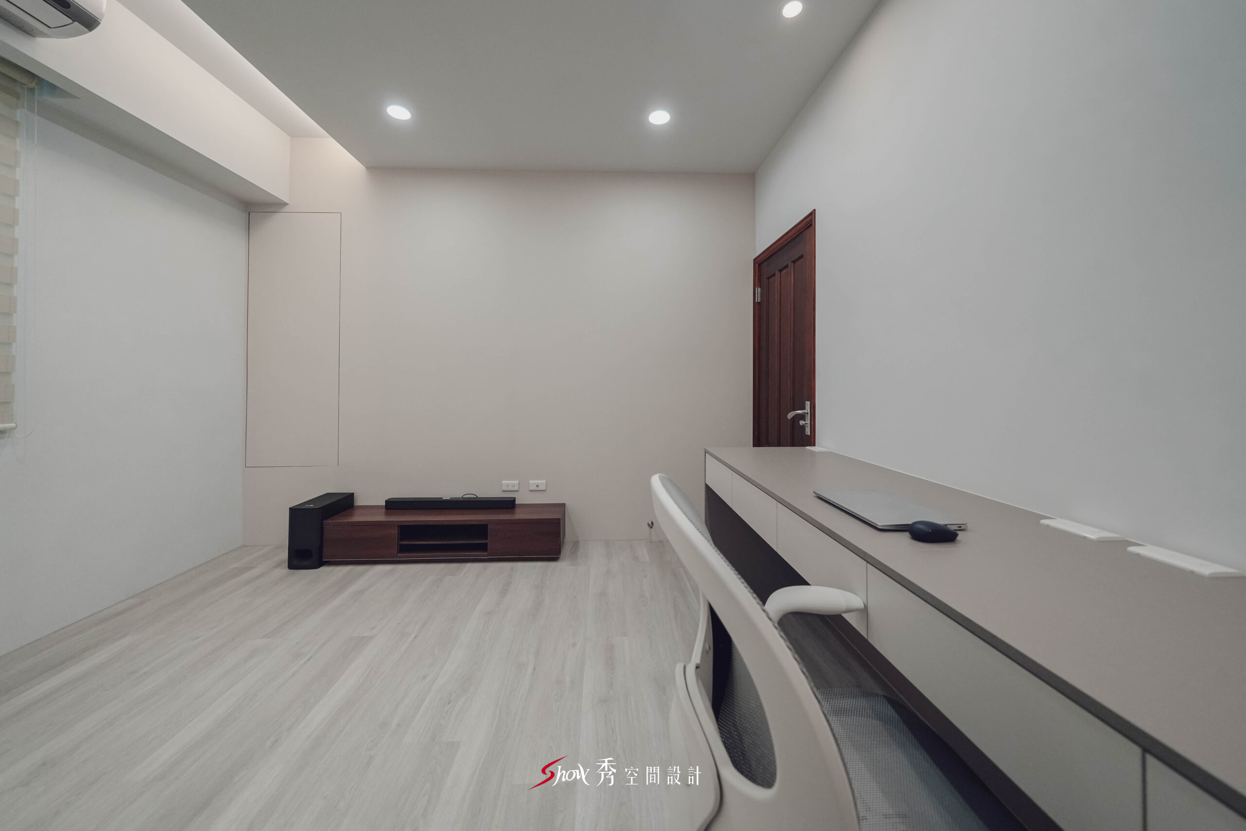 透天老屋翻新書房結合工作桌與低檯度影音櫃，搭配淺灰牆面與簡約收納線條，呈現俐落沉穩的現代空間感。