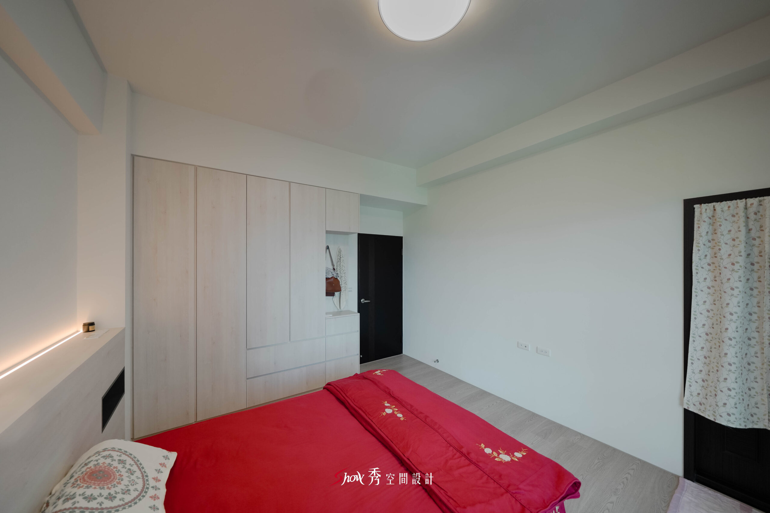 臥室床鋪配置，淺木地板搭配簡約牆面設計