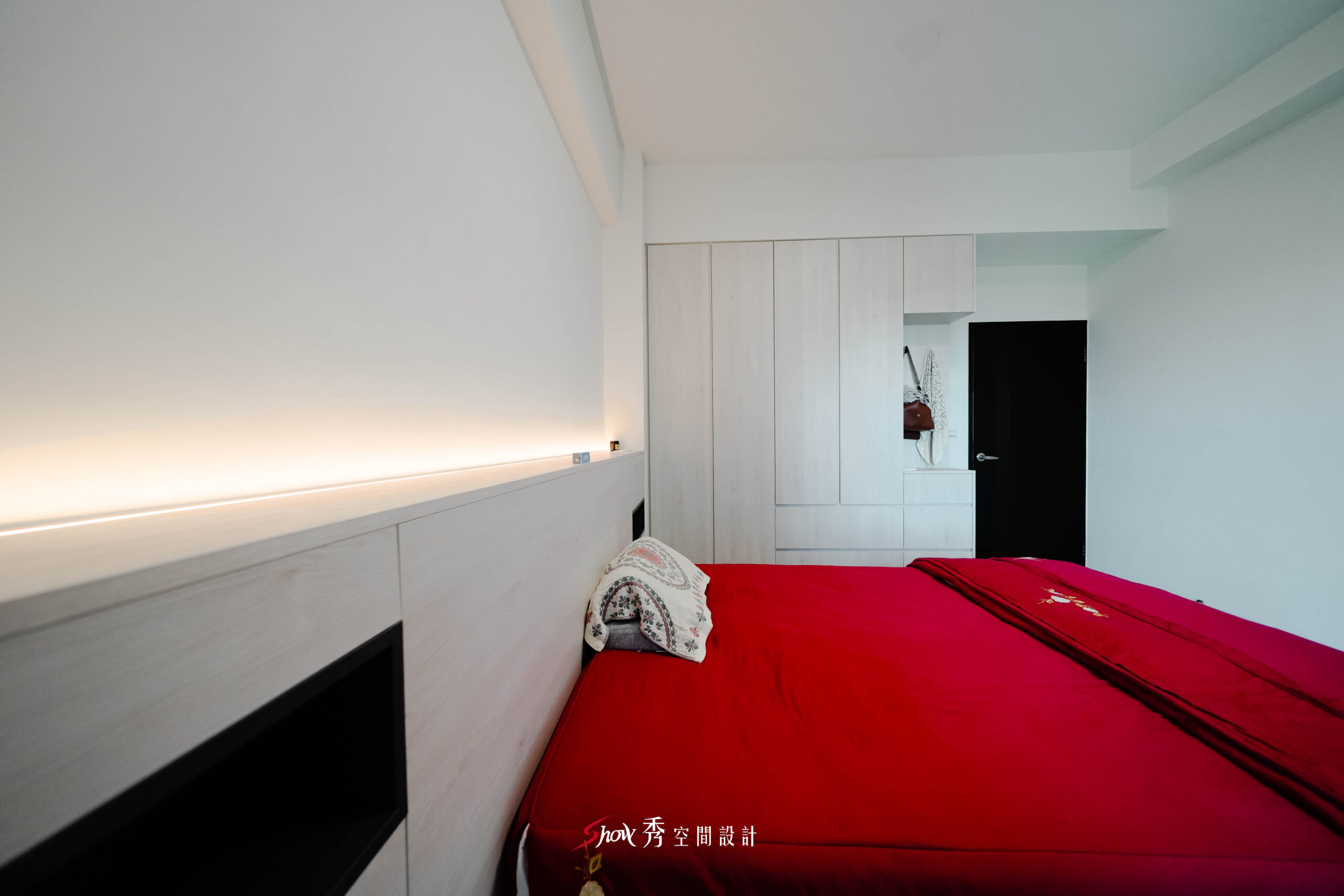 臥室床頭背牆細節，間接燈光與木質立面