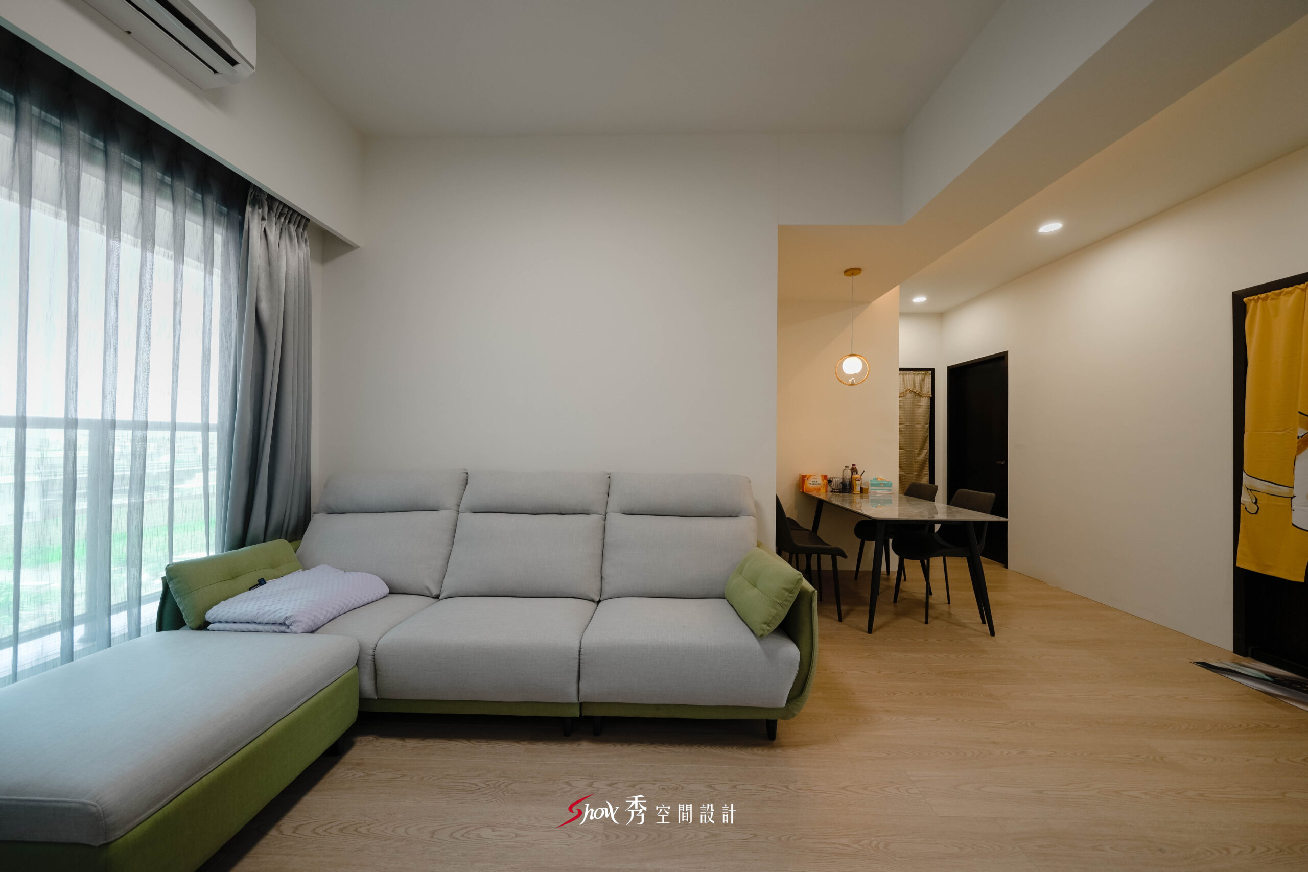客廳空間設計，L 型沙發搭配落地窗採光