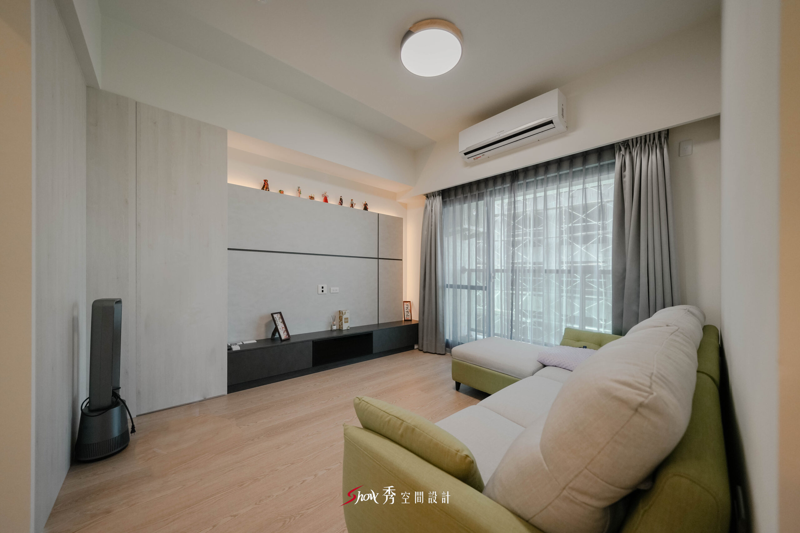 客廳全景視角，沙發、電視牆與窗景配置