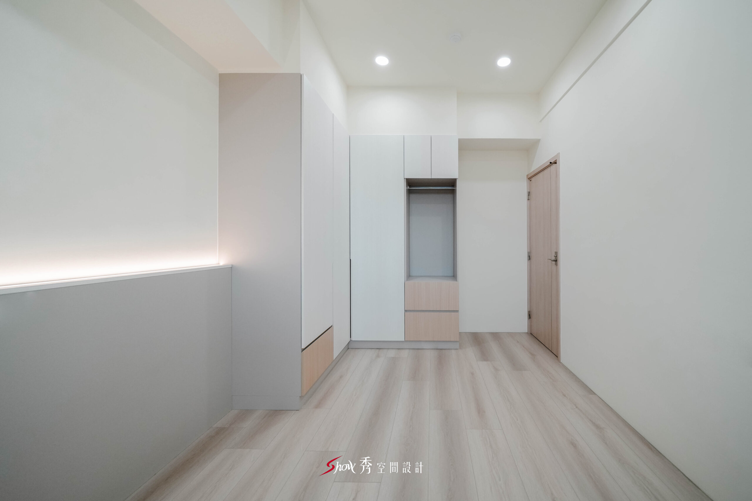 台南新市室內設計臥室空間，採用白色系統衣櫃、淺木色地板與簡約收納設計，打造乾淨明亮的小坪數居家空間。