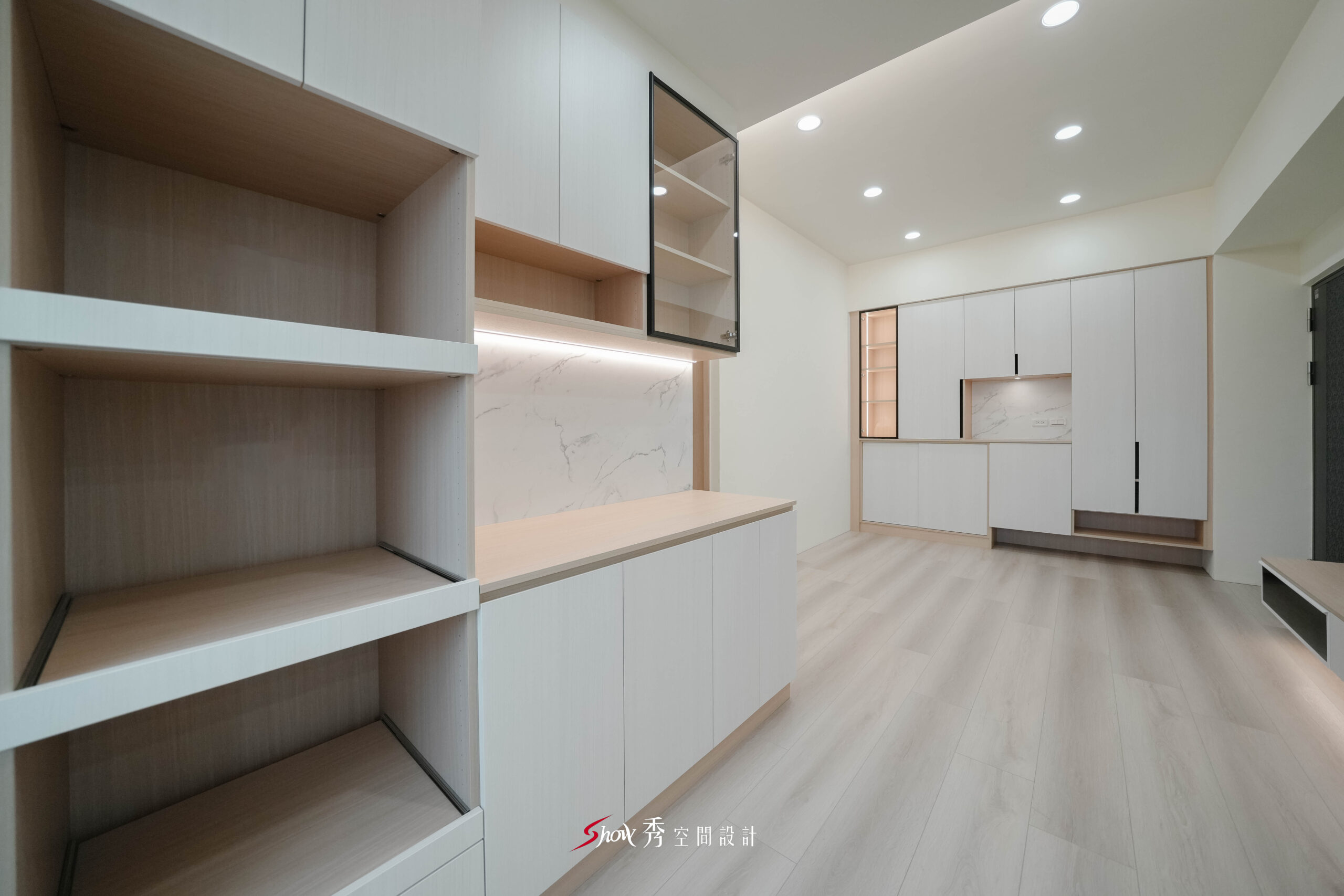 台南新市室內設計，近景呈現餐邊櫃開放層架、石紋背板與遠端玄關收納櫃。