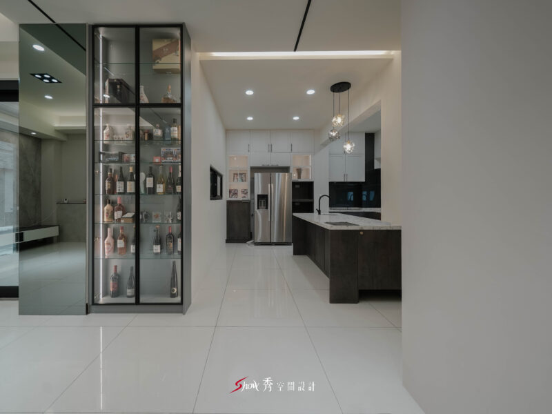 台南善化住宅設計展示櫃空間，以黑框玻璃酒櫃結合開放式廚房規劃，展現現代質感。