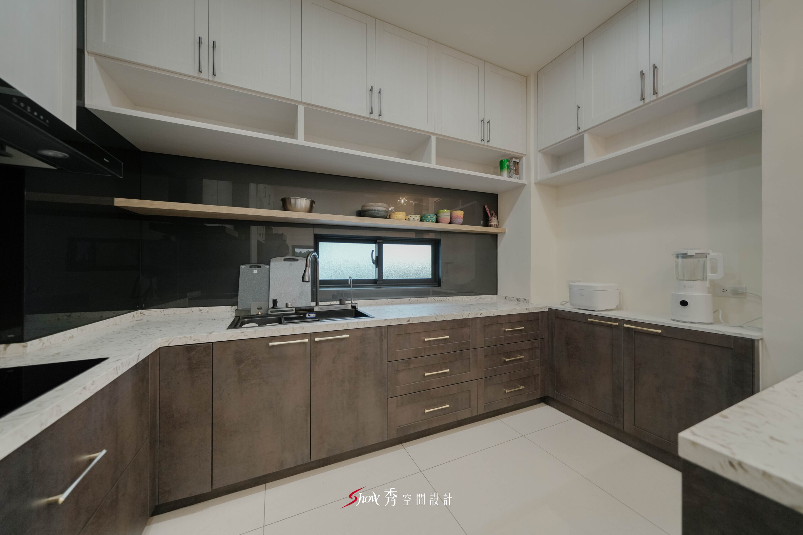 台南善化室內設計|4大空間規劃重點|南科家庭裝修首選 台南室內設計L型廚房規劃,黑色玻璃背牆搭配木質層板與大量收納櫃體設計。