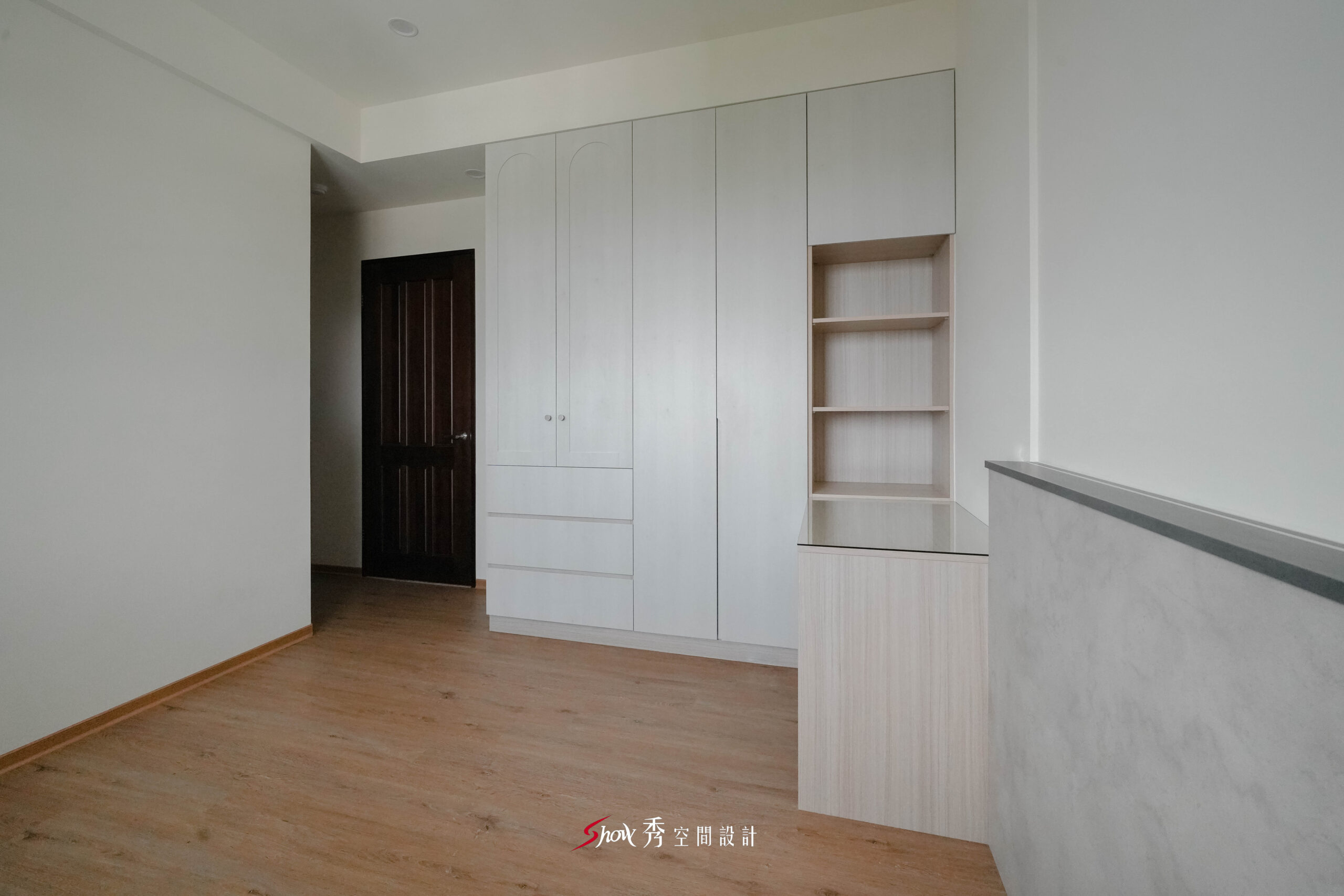 臥室衣櫃與書桌一體成形設計，搭配灰質感半高牆，塑造分區明確的居家空間。
