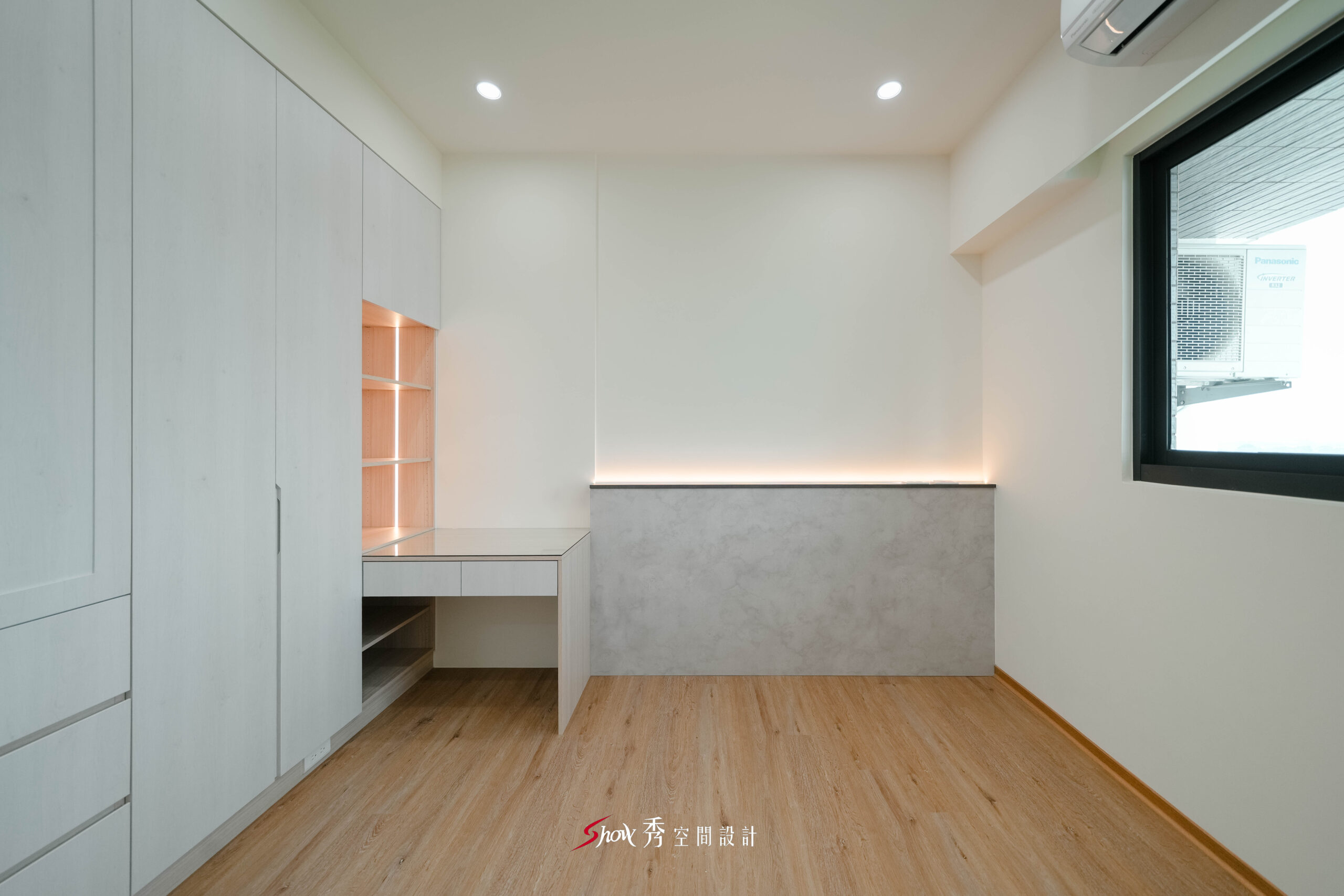 臥室整合衣櫃與書桌收納設計，搭配燈帶層板提升使用與展示機能。