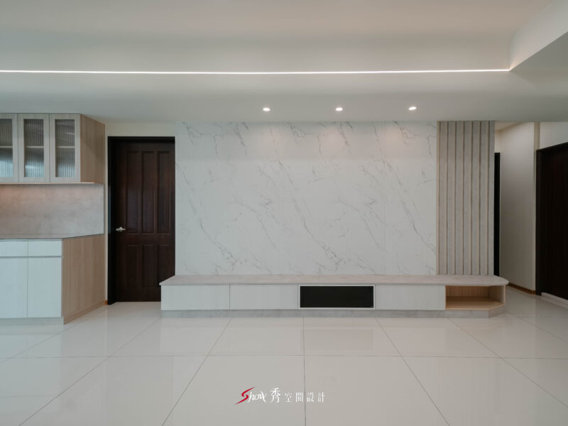 客廳主牆採大理石紋設計搭配長型電視櫃，呈現橫向延伸的空間感。