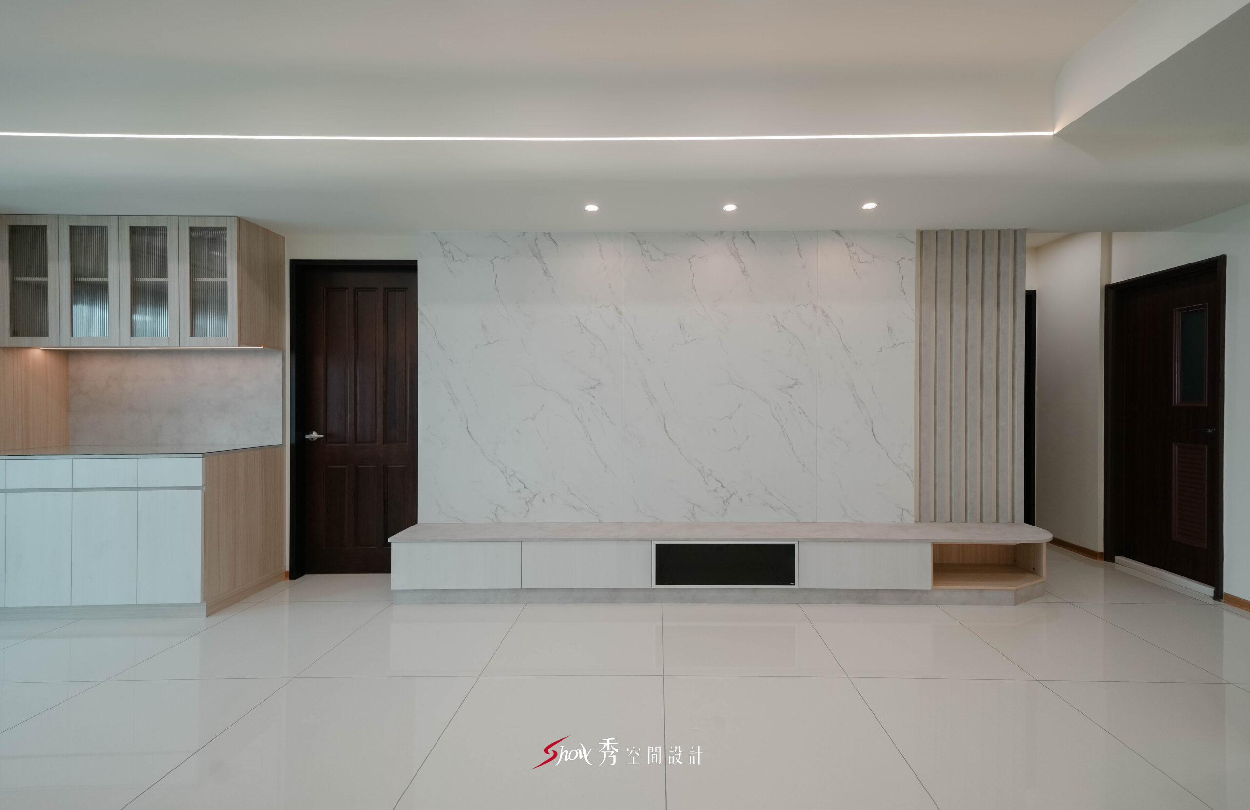 客廳主牆採大理石紋設計搭配長型電視櫃，呈現橫向延伸的空間感。