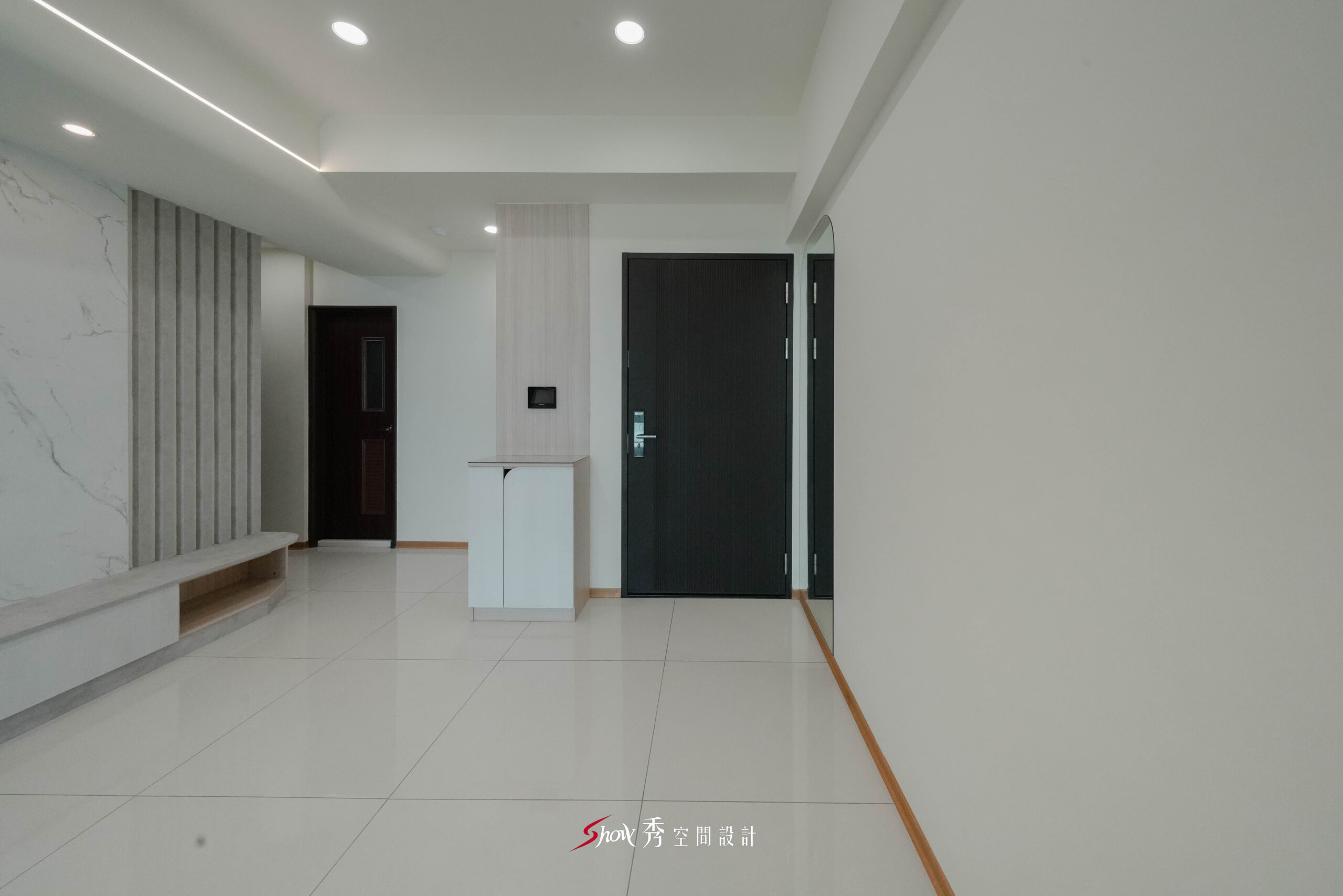 客廳入口結合玄關櫃與電視牆設計，打造簡潔俐落的居家動線。