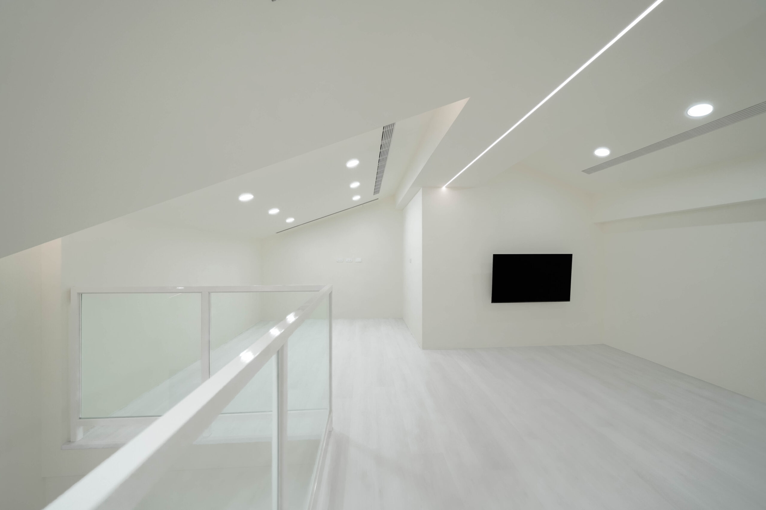 善化室內設計案例，閣樓空間結合玻璃欄杆與線型燈光設計，展現現代簡約風格。