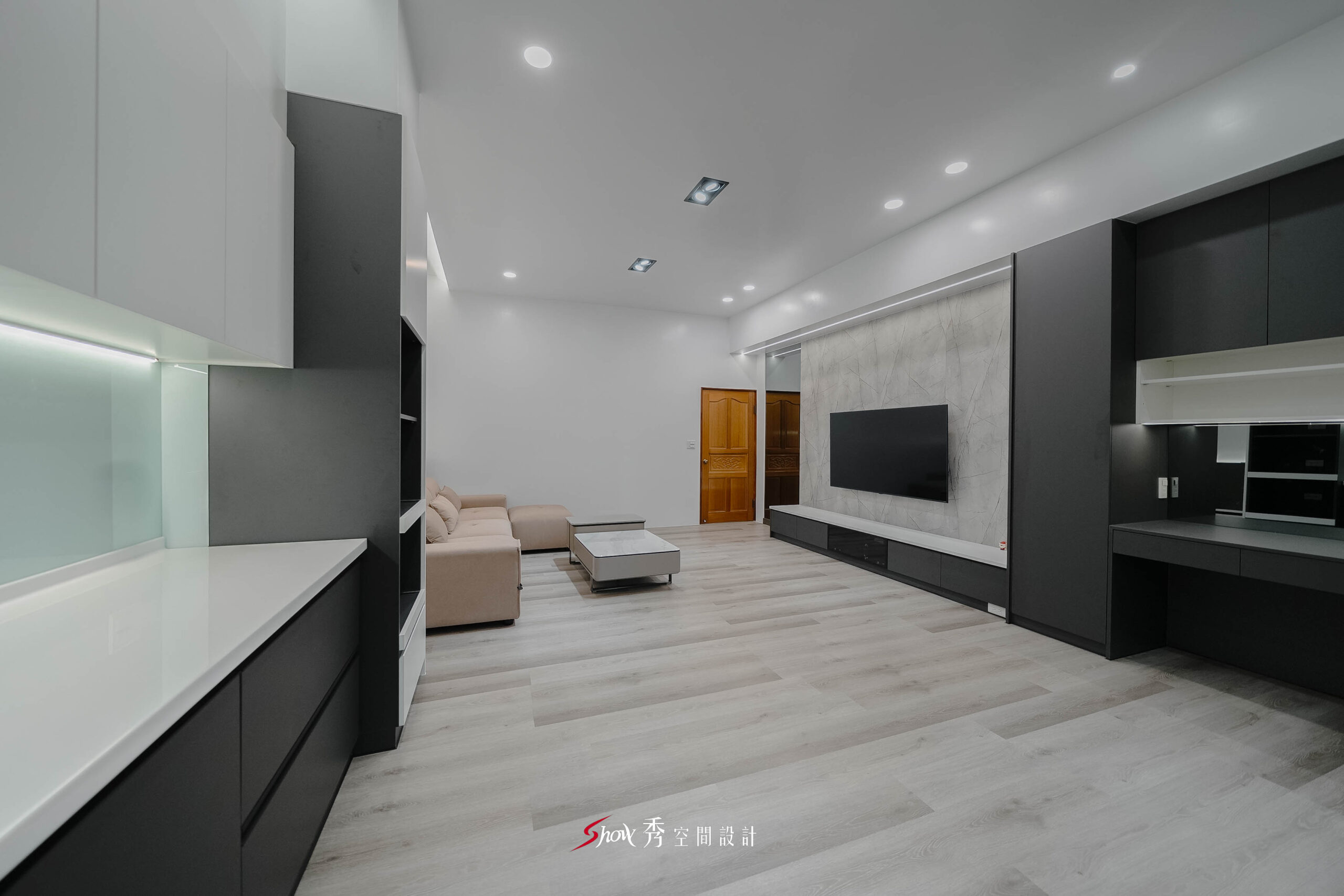 台南老屋翻新簡約住宅公共空間，石紋電視牆搭配深灰收納櫃與淺木紋地板