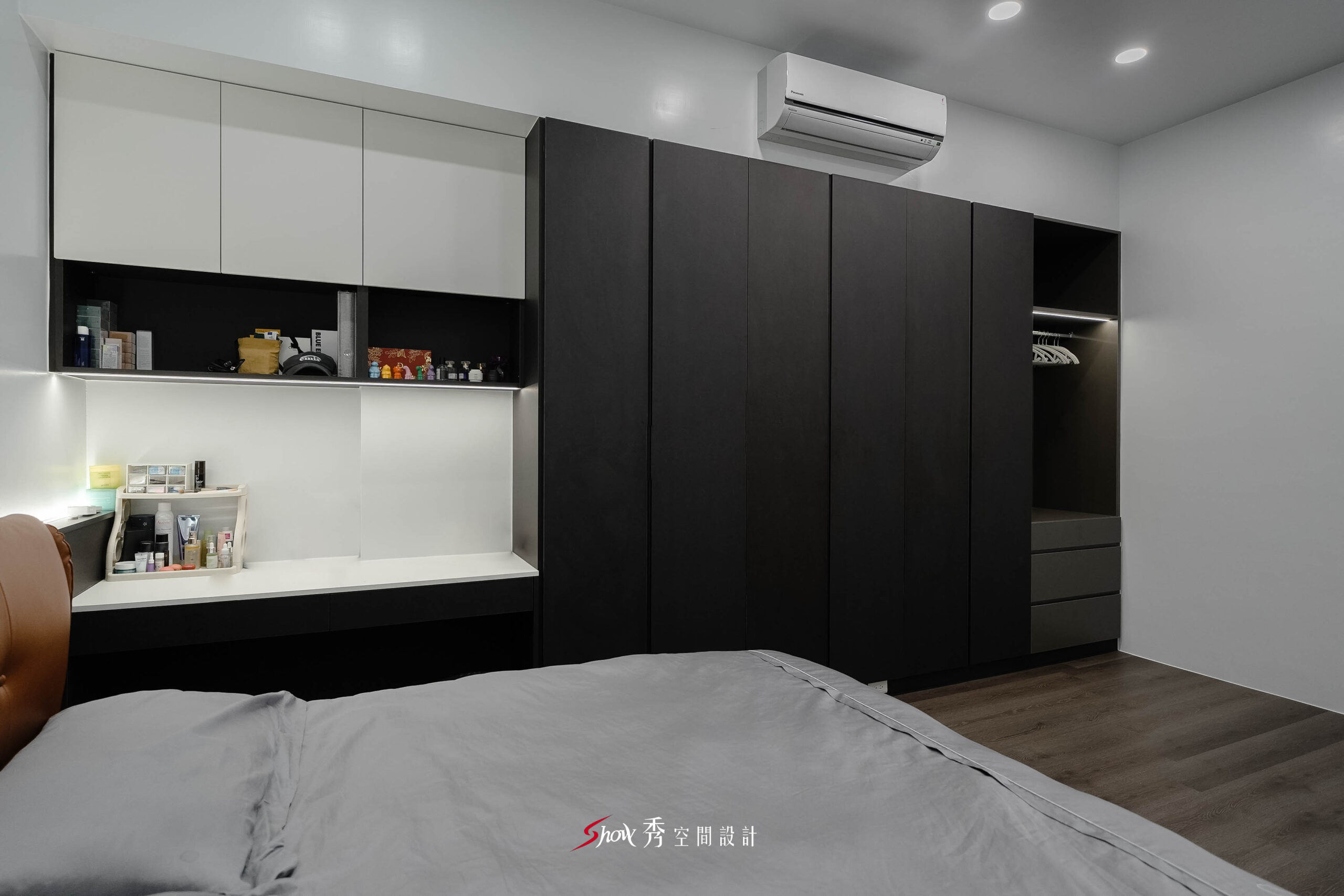 台南老屋翻新主臥室設計，黑色大型衣櫃結合白色化妝桌與開放式吊衣區