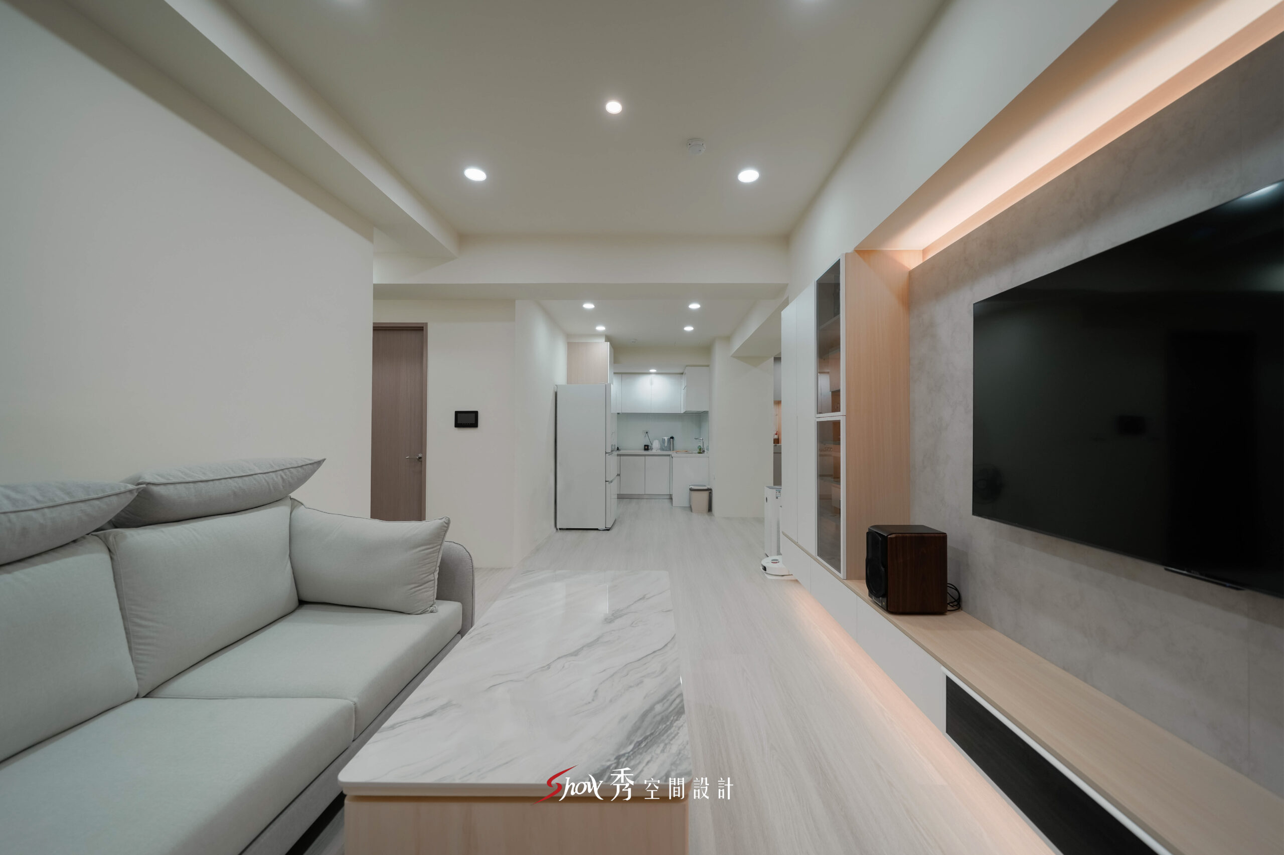 台南現代簡約客廳設計，以石紋電視牆、淺木紋茶几與開放式格局打造舒適住宅空間。