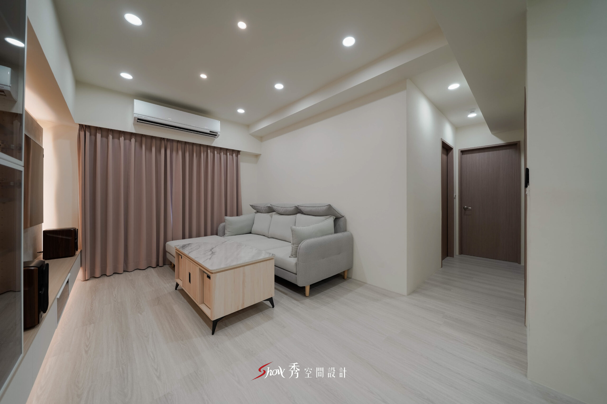 台南客廳空間設計，以現代簡約風格搭配粉色窗簾與灰色沙發，打造溫馨舒適住宅。