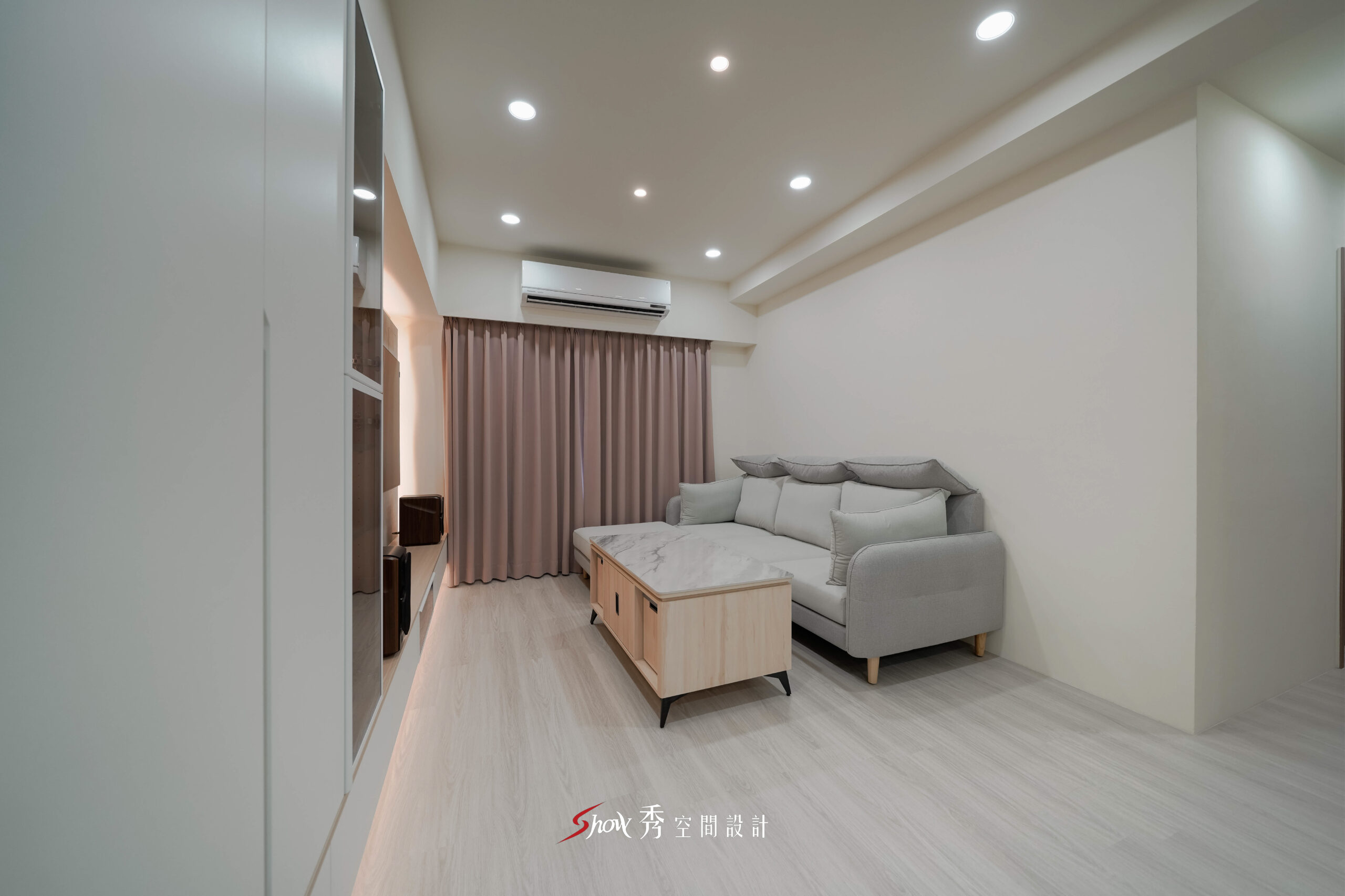 台南現代簡約客廳規劃，以淺色木紋、灰色沙發與石紋電視牆打造簡潔明亮空間。