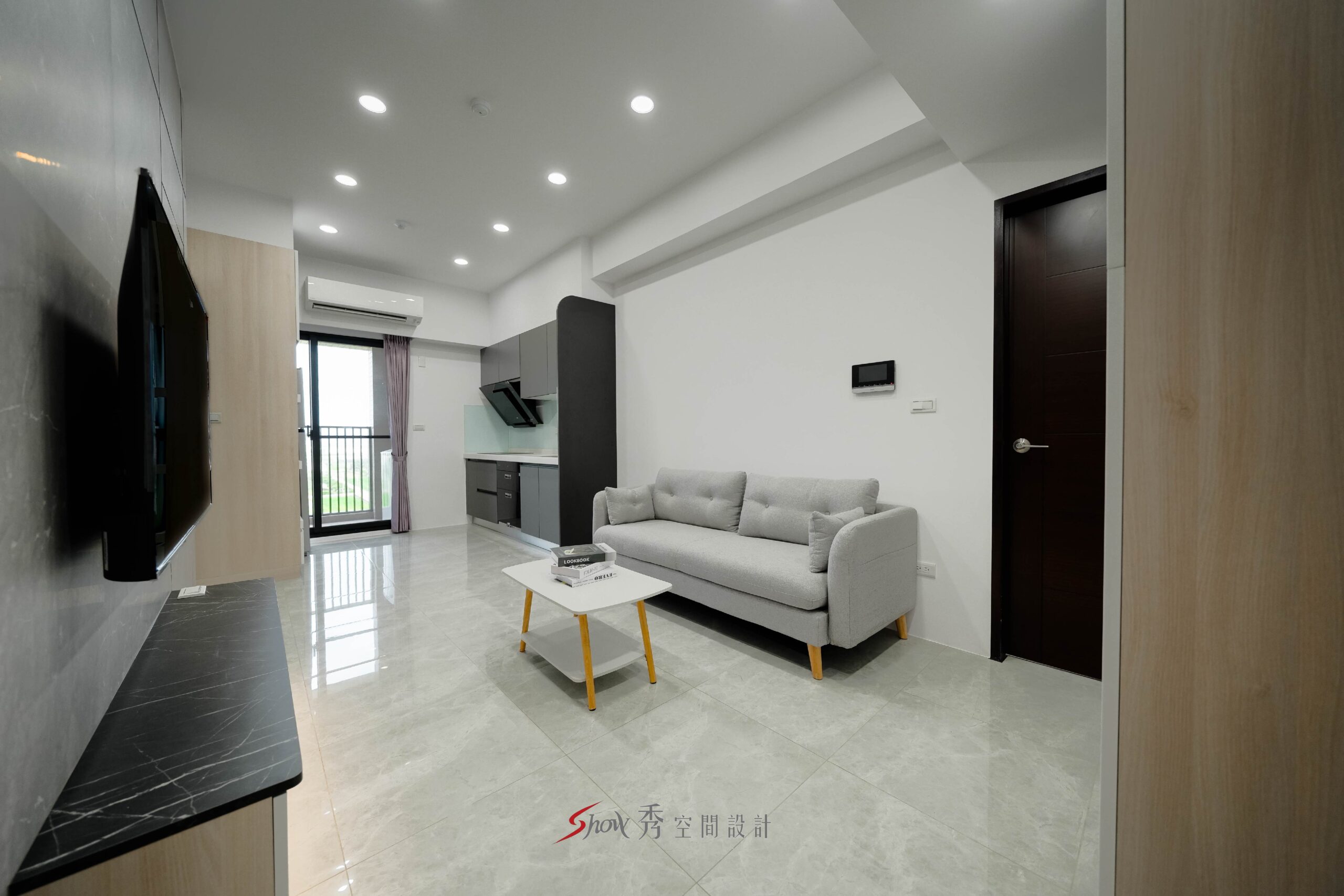 小宅客廳配置淺灰沙發與白色茶几，後方銜接一字型廚房與陽台採光