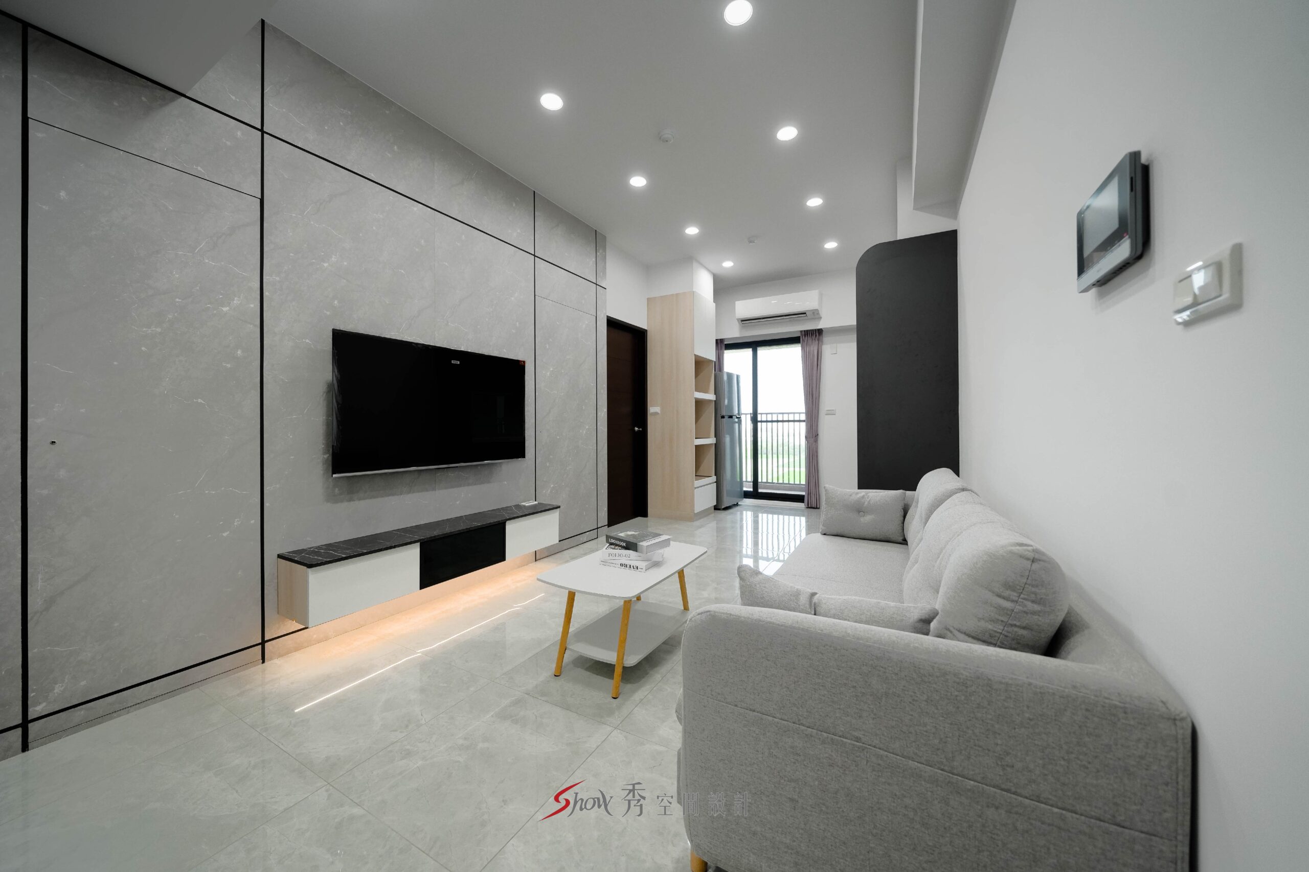 客廳灰色石紋電視牆、淺灰沙發與白色茶几構成的現代簡約住宅空間