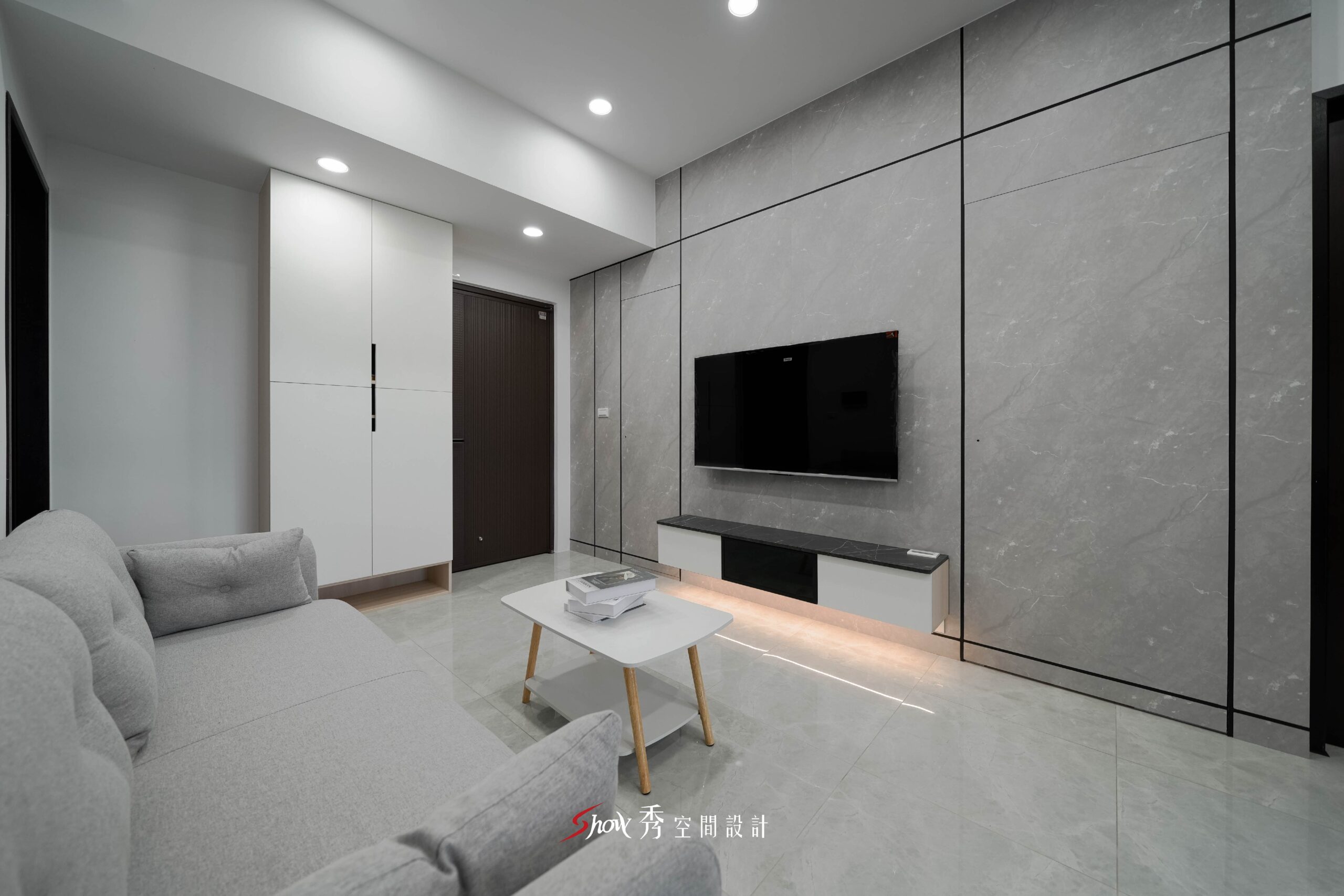白色玄關櫃結合灰色石紋電視牆與小茶几的現代簡約客廳空間
