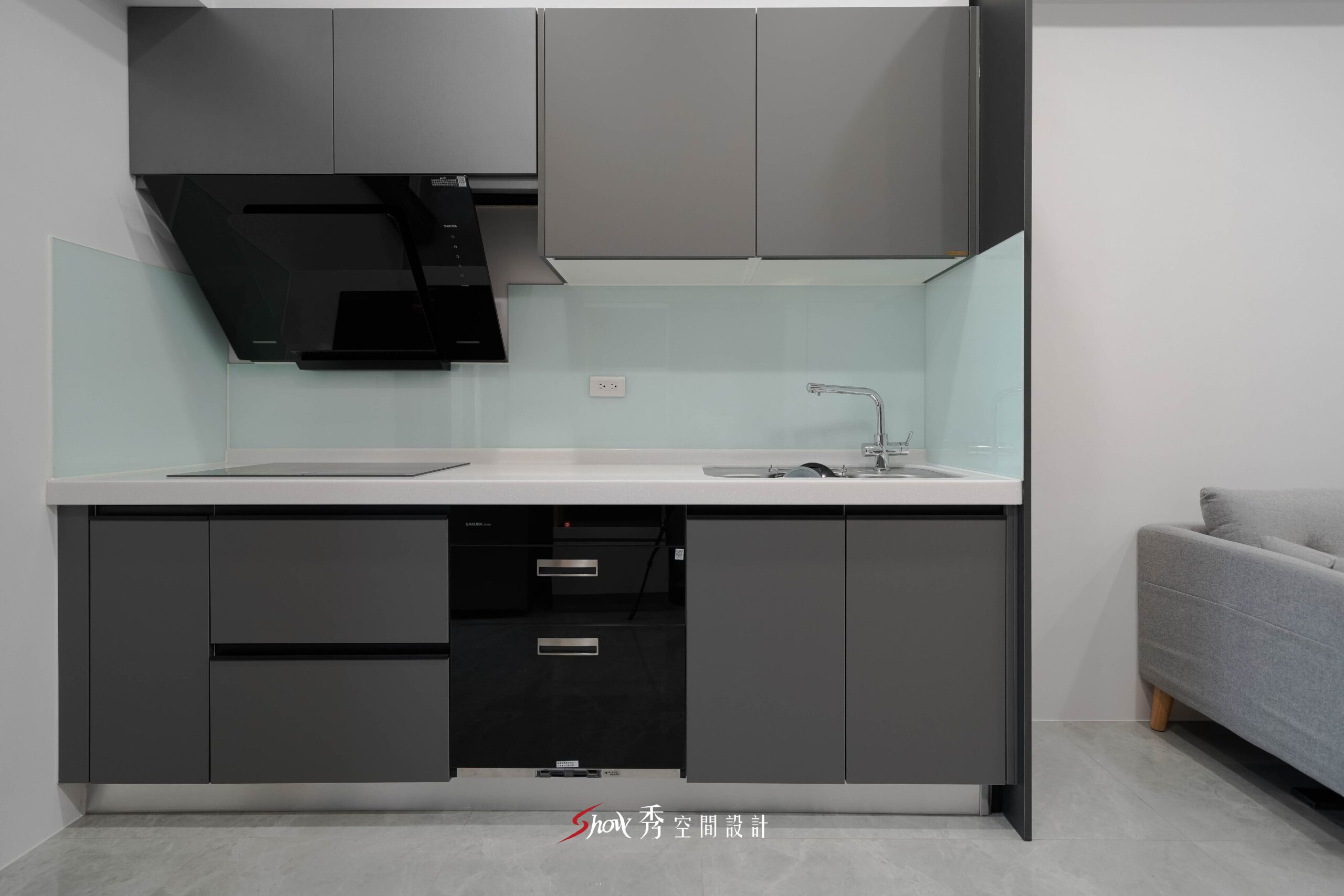 灰色一字型廚房櫥櫃搭配白色檯面與淺色玻璃 backsplash 的現代簡約廚房空間