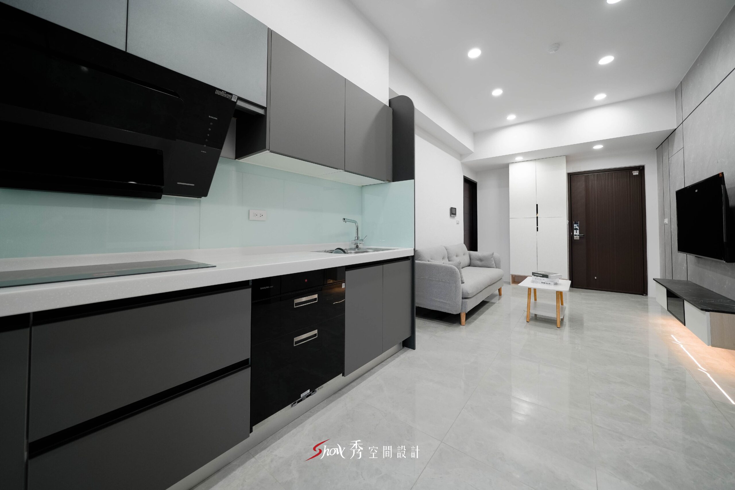 灰色一字型廚房櫥櫃搭配白色檯面與開放式客廳的住宅空間